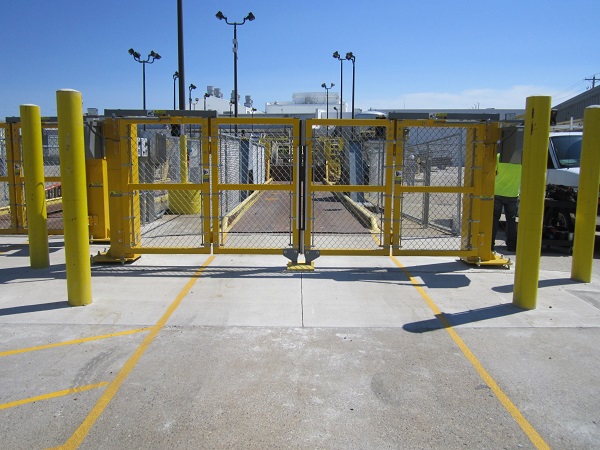 A mesh wired automatic bifolding gate in yellow colour used in commercial property.